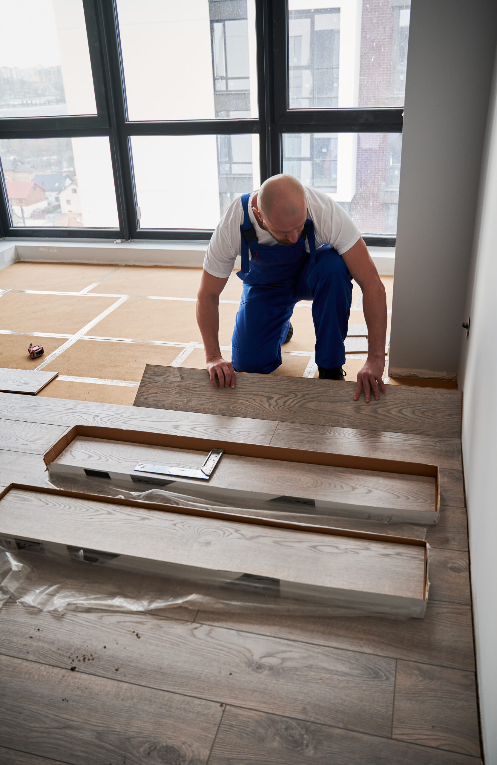 Man installing laminate flooring in apartment under renovation. man installing lamaniant